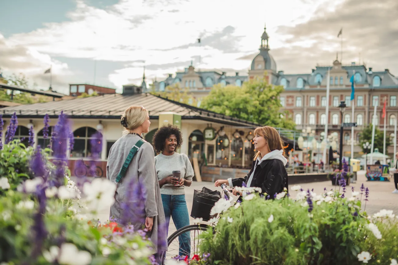 En grupp kvinnor som står bredvid varandra. Sundsvalls stenstad i bakgrunden.