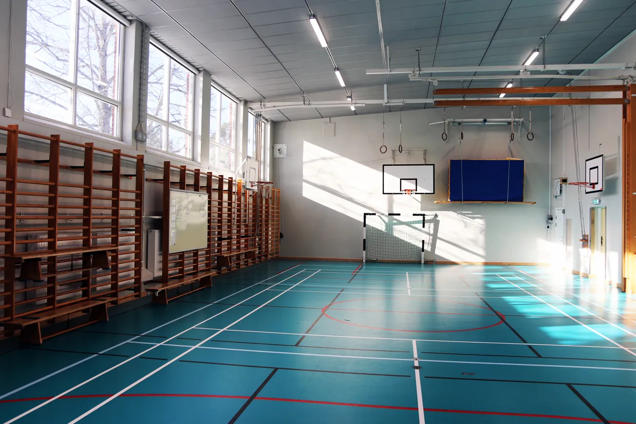 En basketplan inne i en byggnad med en basketkorg.