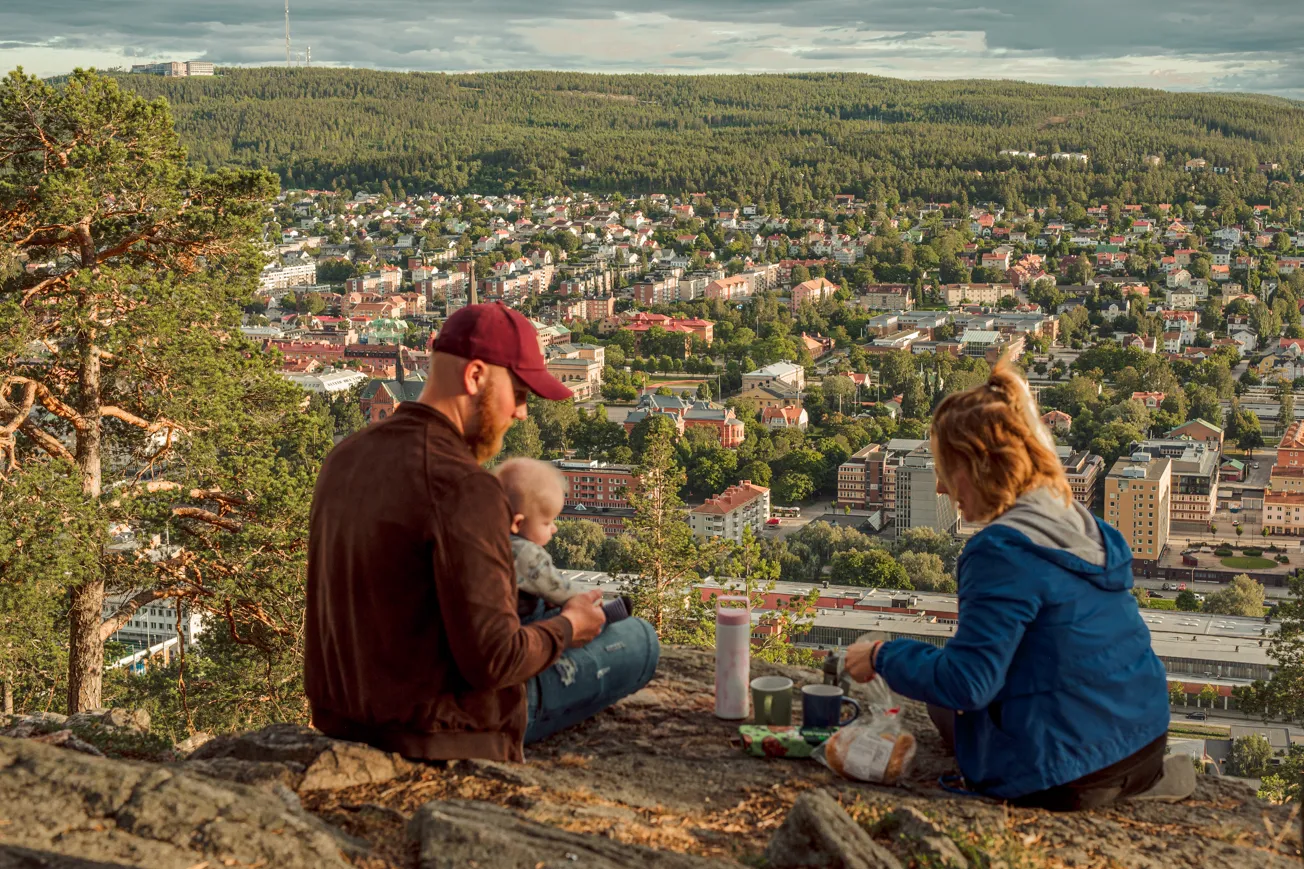 Familj fikar på Norra berget med utsikt över staden.