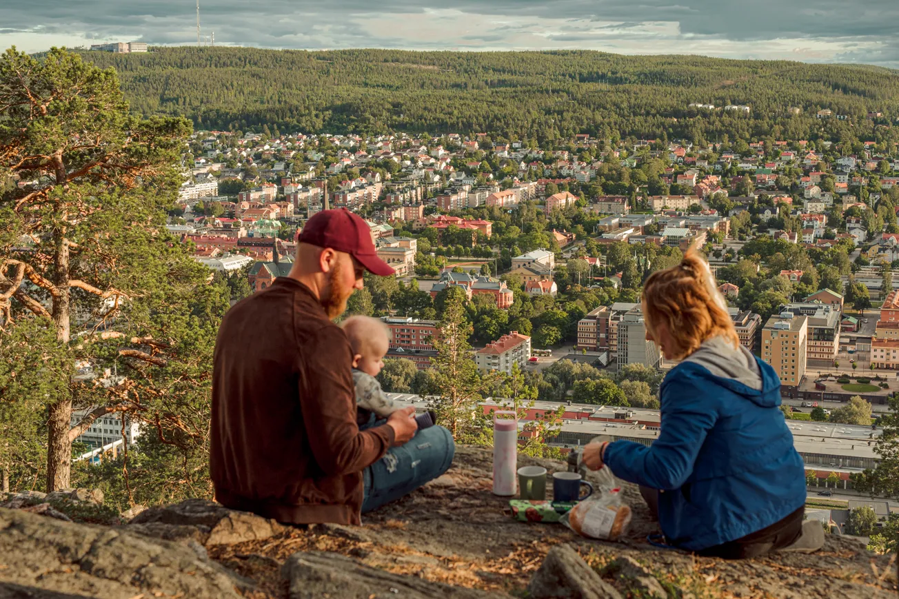 En man och en kvinna sitter på toppen av en kulle.