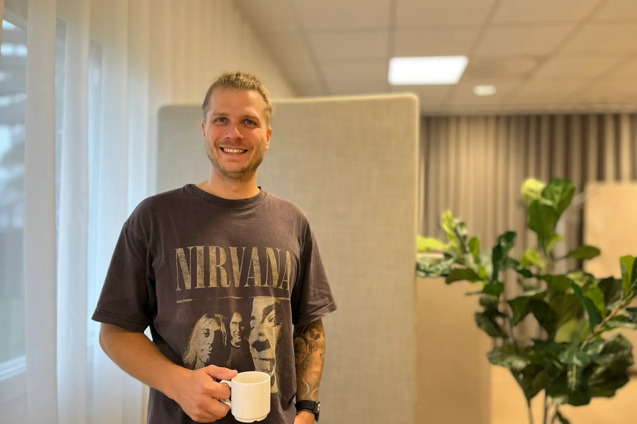 Michael som studerar på Yrkeshögkolan Mitt står med en kaffekopp i handen på Lärcentrum.