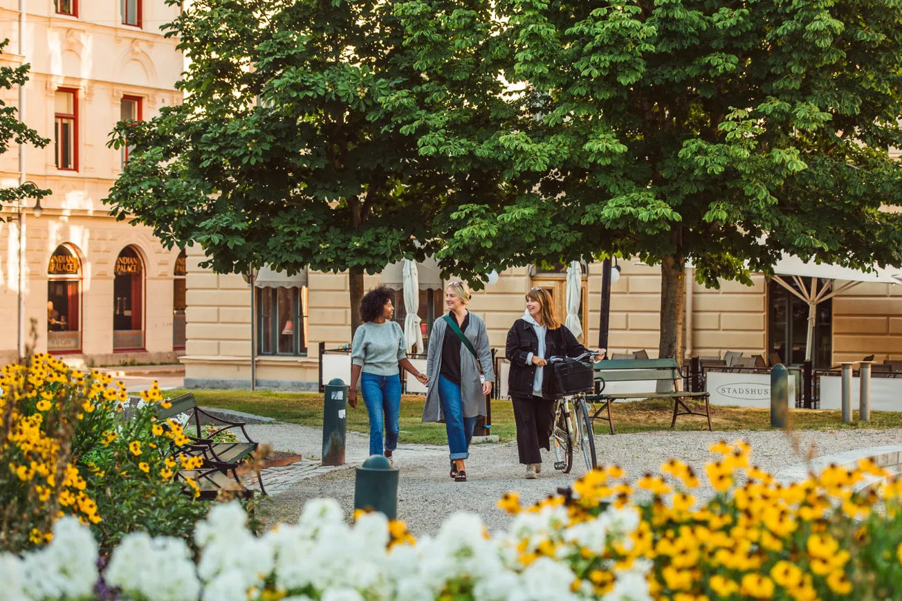 En grupp människor som går längs en trottoar.