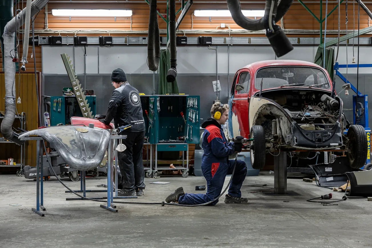 Några män som arbetar med en bil i ett garage.