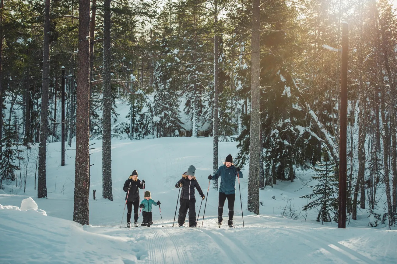 En grupp människor som åker skidor nedför en snötäckt sluttning.