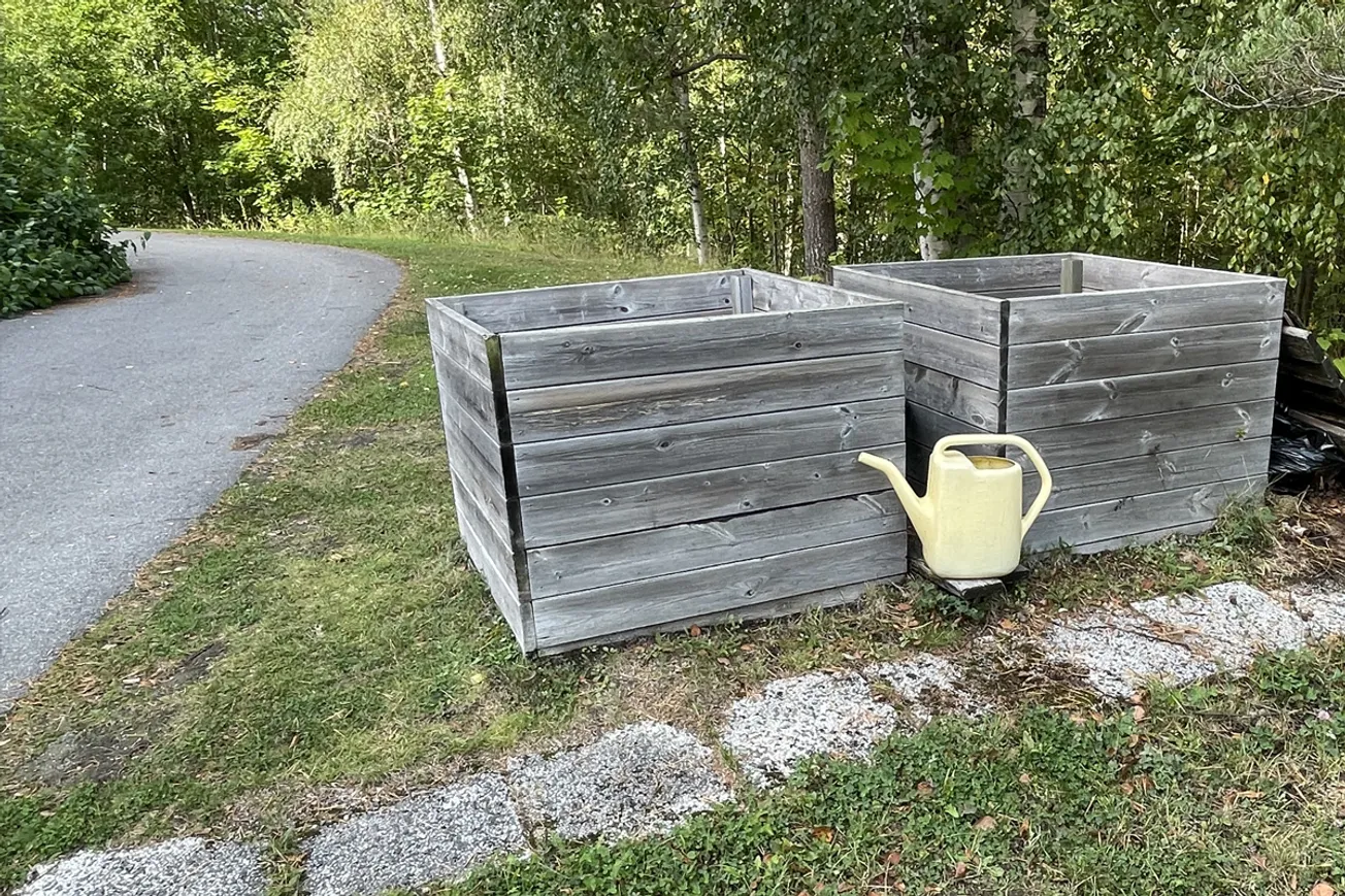 Några trälådor som står på ett gräsbevuxet fält.