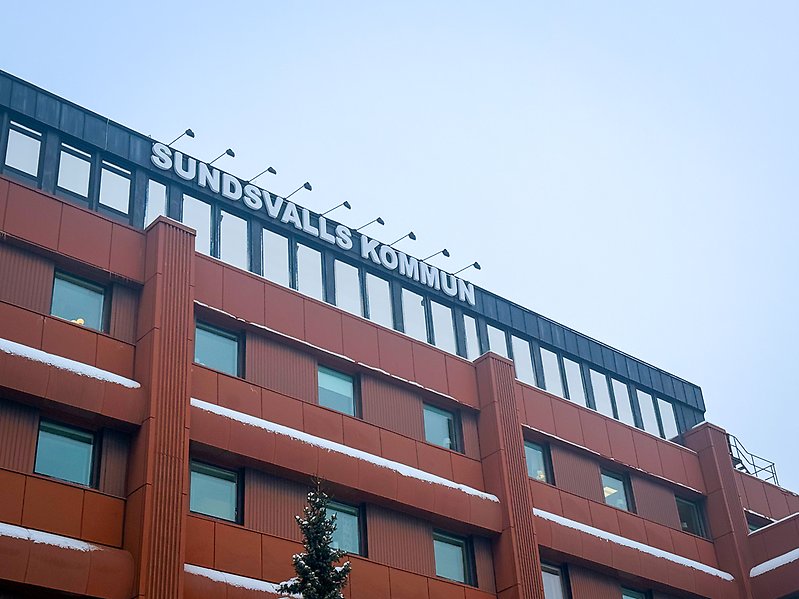 Fasad och skylt på kommunhus med himel som bakgrund. 